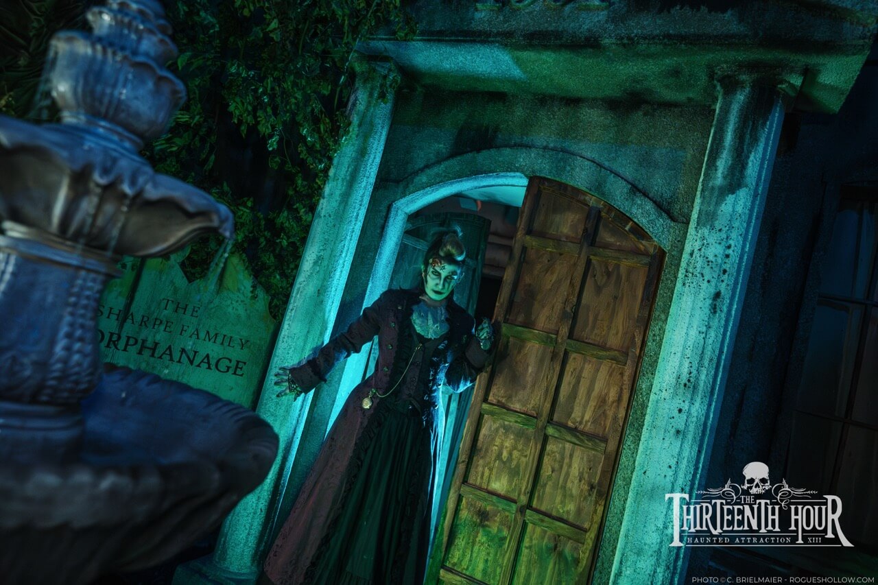 Three guests scream as a scare actor lunges toward them