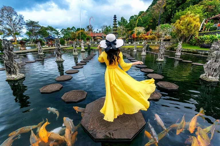 Woman feeding koi fish pool.