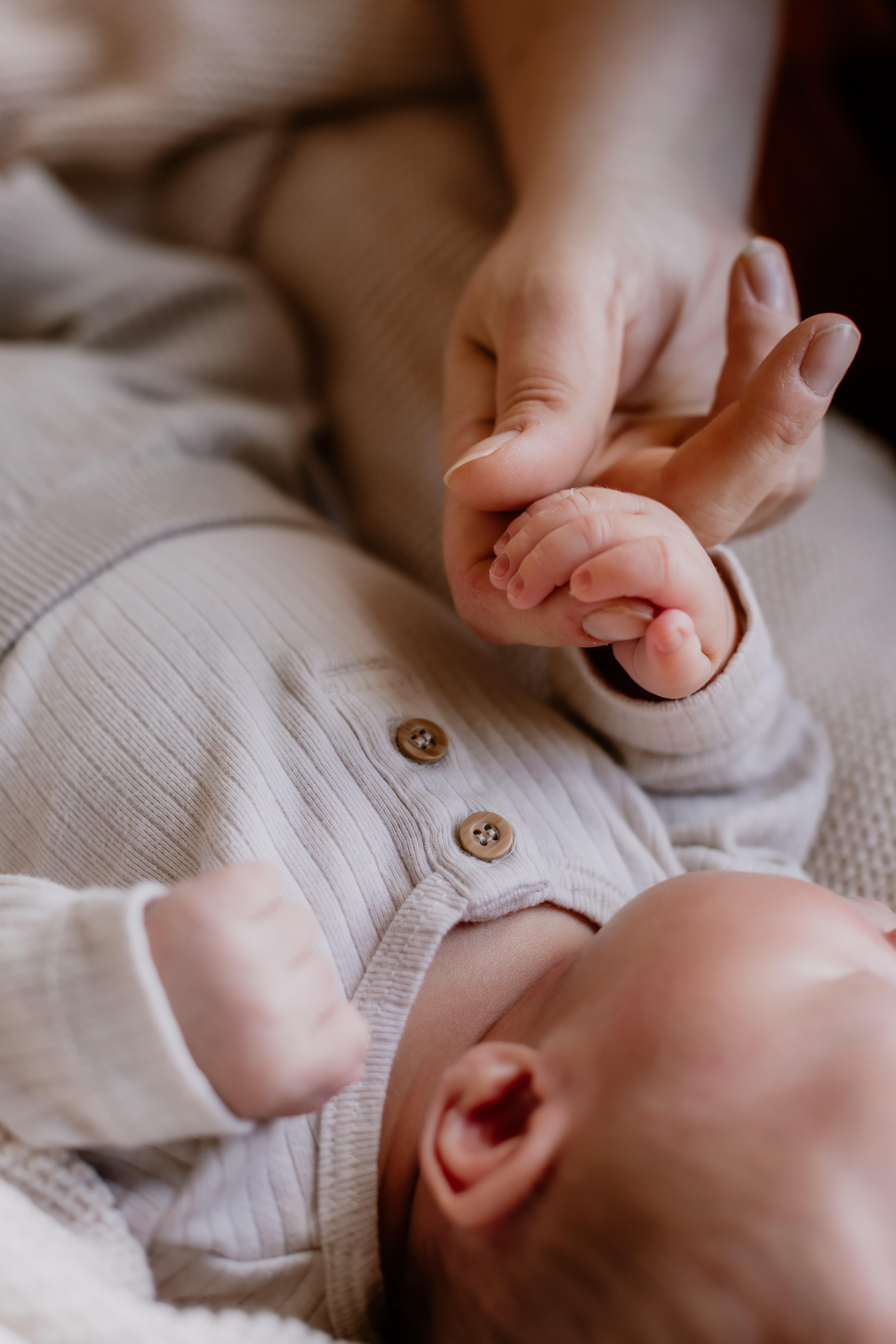 Close up of parent holding newborn baby's hand in newborn photo session in Mackay, QLD