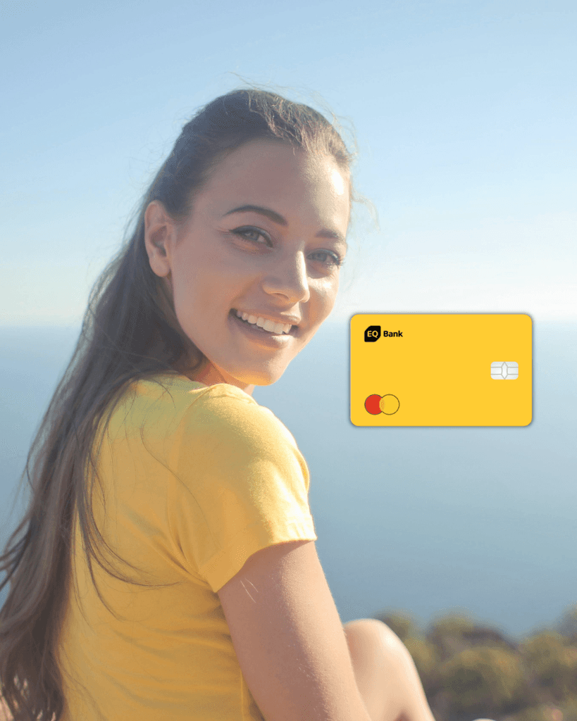 A smiling young woman outdoors next to a yellow EQ Bank Mastercard, representing a smart, no-fee Canadian banking choice for newcomers looking to earn high interest on their savings.
