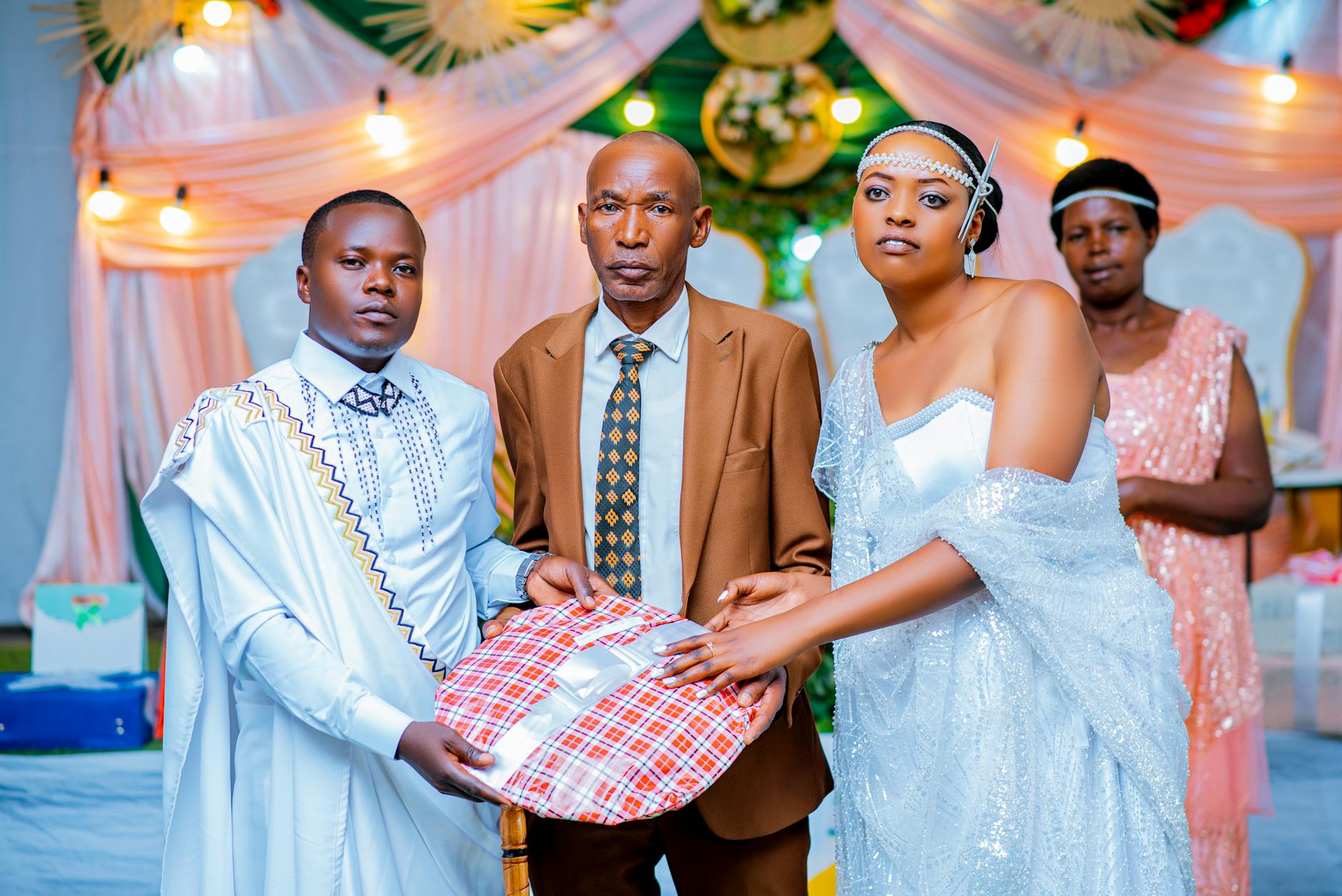 A formal gift exchange at a wedding with beautifully dressed participants.