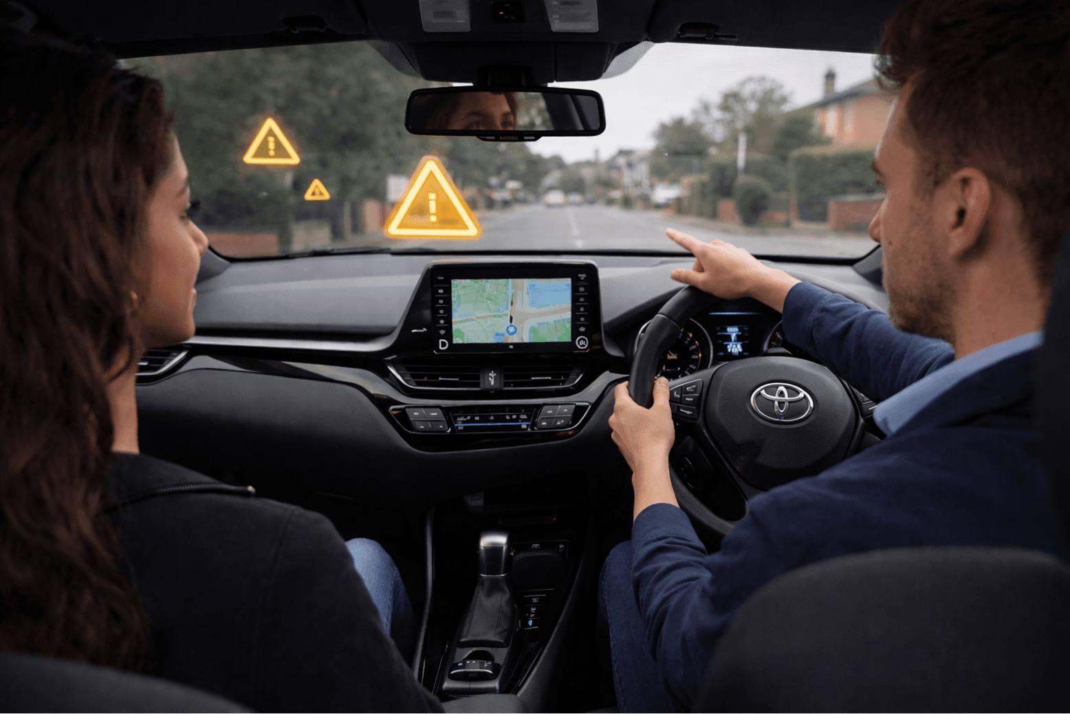 Driving instructor guiding a learner in an automatic Toyota car during a lesson