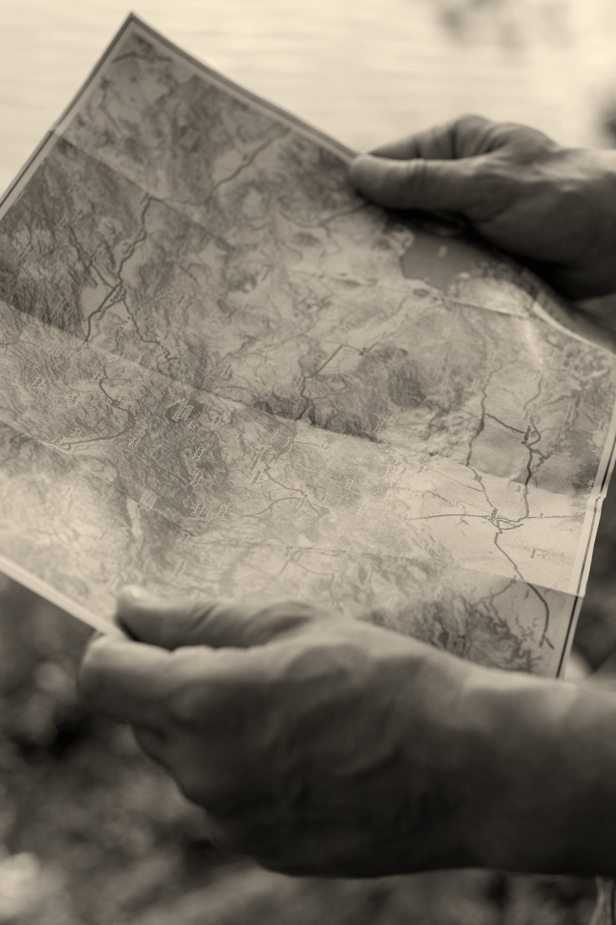 Hands holding a paper map outdoors