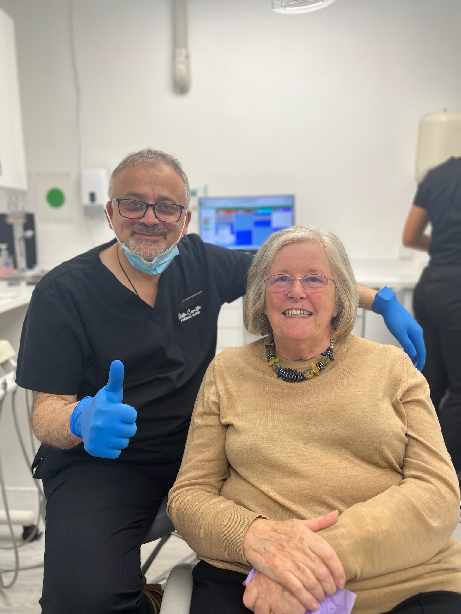 a photo of a dentist and his nurse working on a patient
