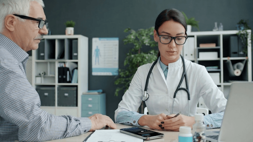 Clinician speaking with a patient beside an iPhone showing Solanto