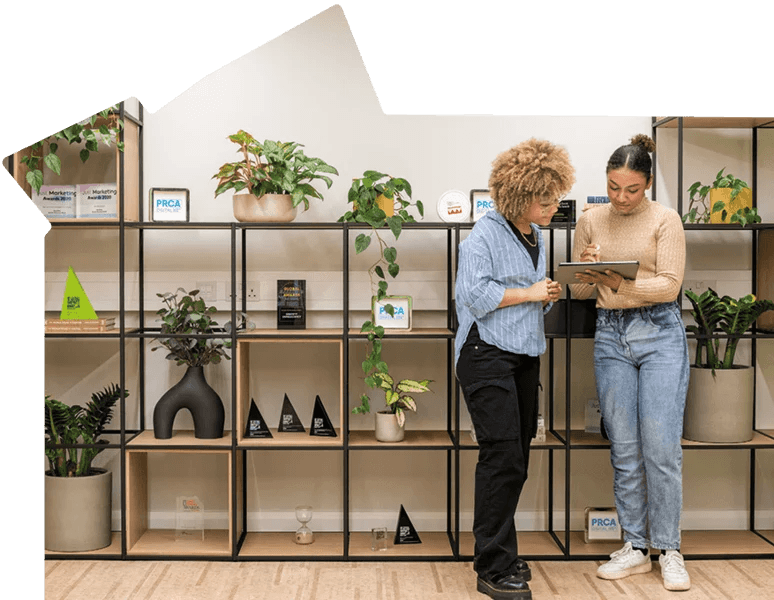 Two people looking at plants and flowers on display.