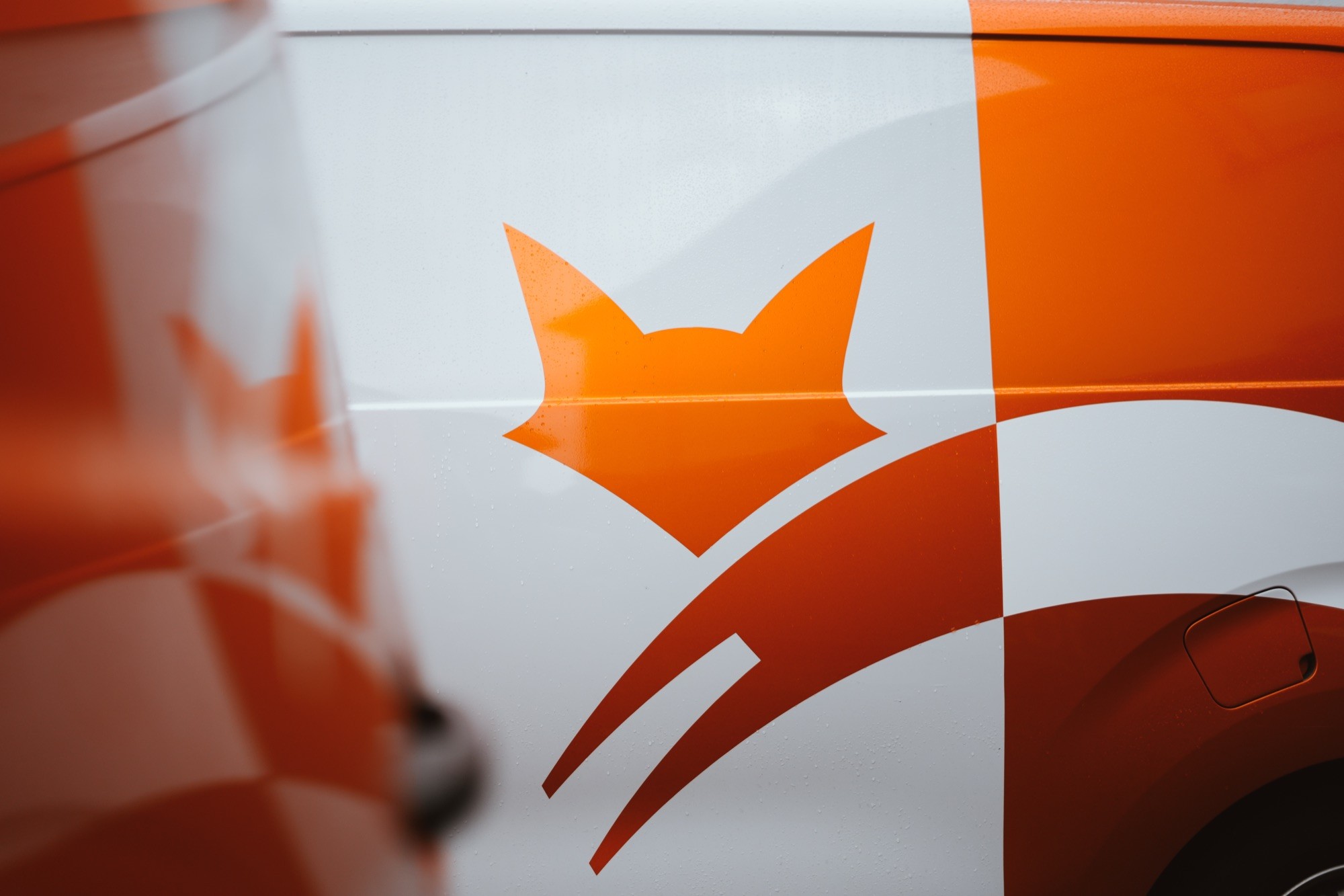 Oranges Fuchs-Logo auf der Seite eines Firmenwagens