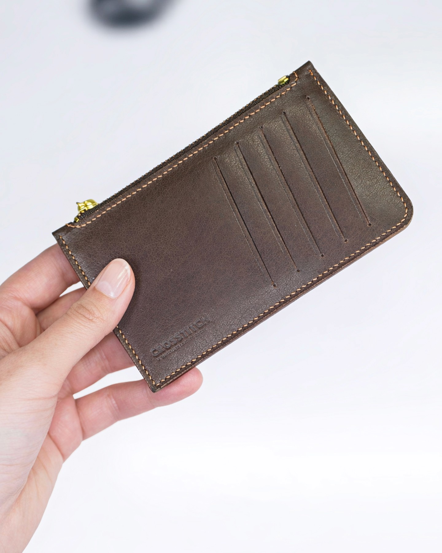 Handcrafted brown leather money envelope by Crosstitch Leather, featuring an angular flap design and embossed cat emblem.