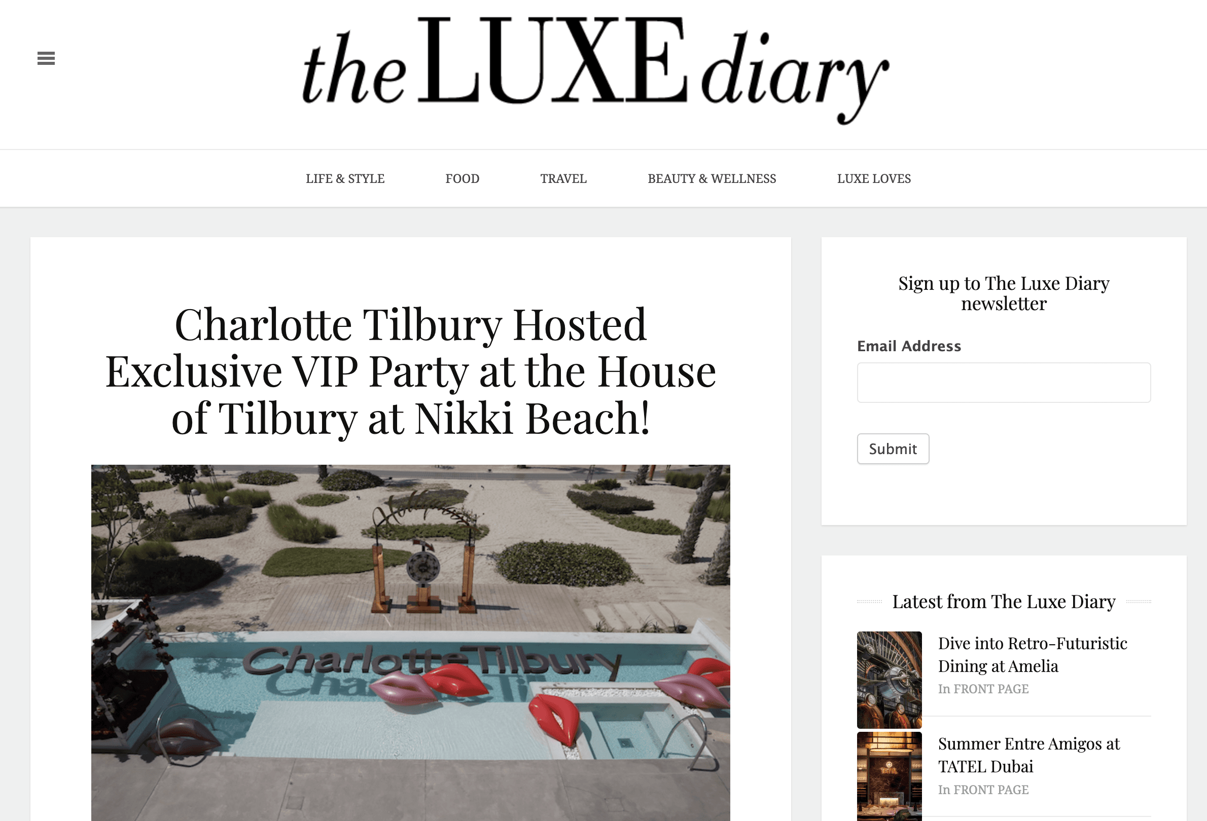 Black-and-white party photo of a smiling man in a check blazer among a crowd.