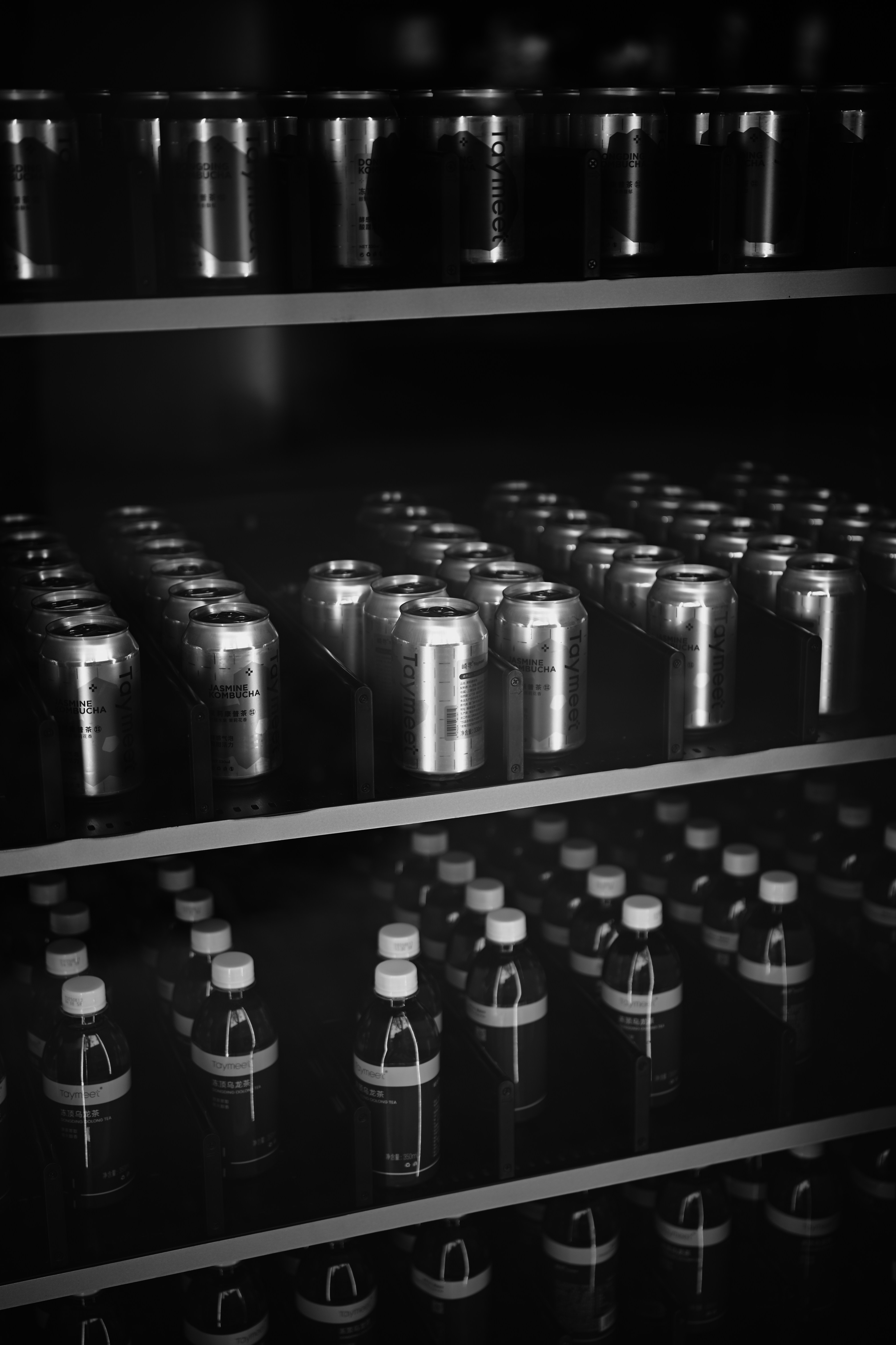 Rows of aluminum cans and glass bottles on shelves