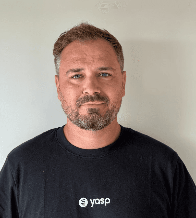 A man in a suit and tie leaning against a wall