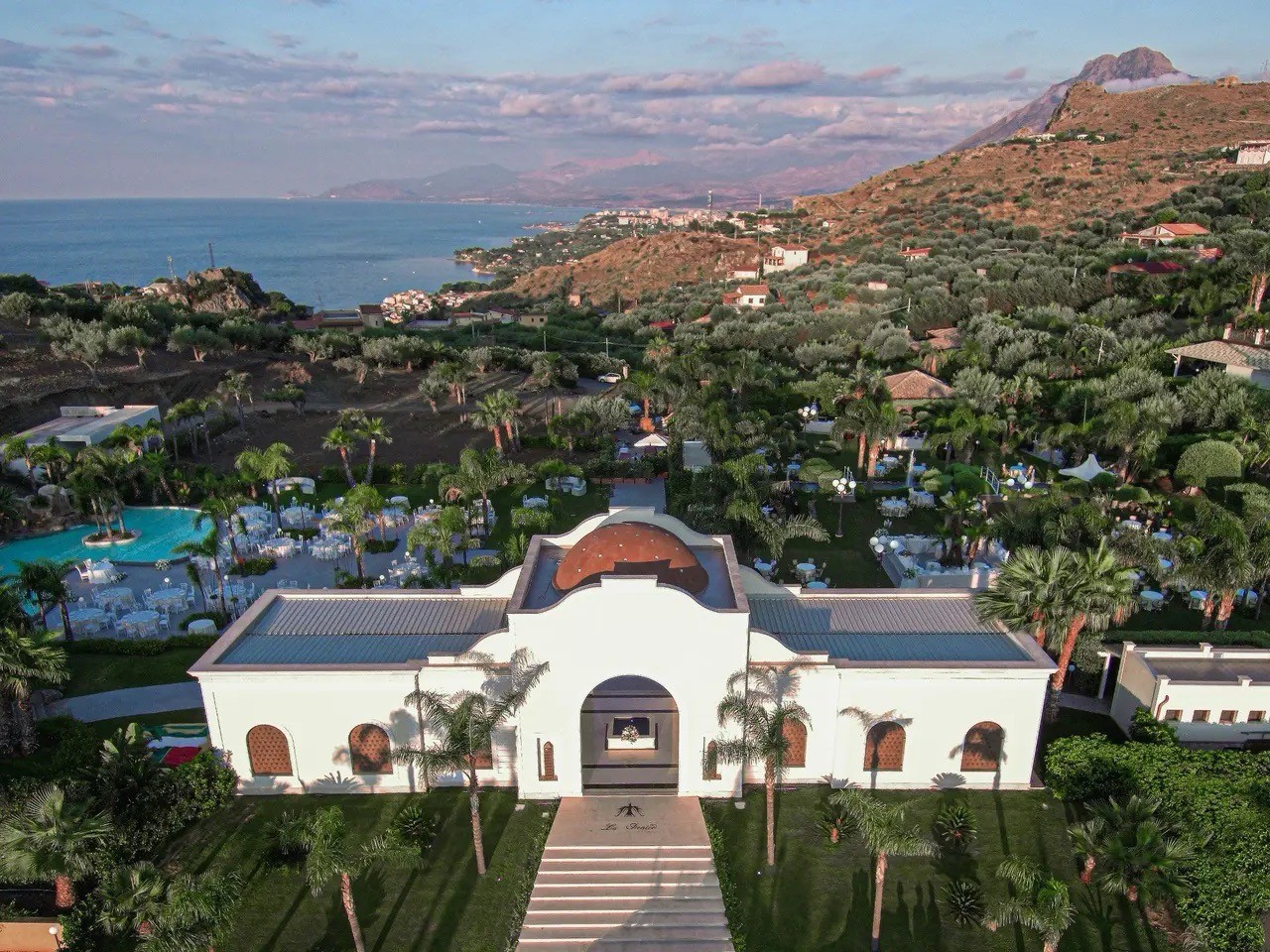 brown building near a rock formation near body of water during daytime