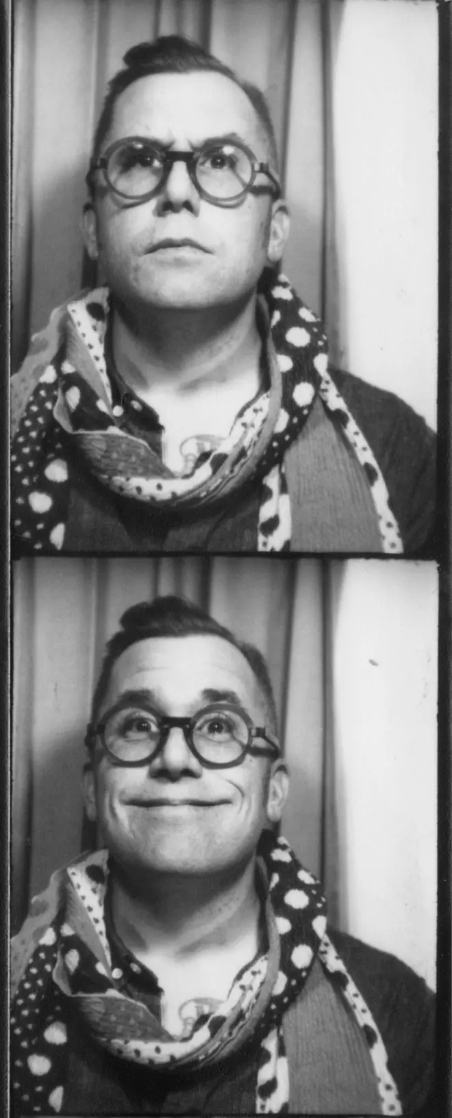 Black and white photo booth strips showing Rob Harrigan with glasses and a polka dot scarf making a neutral expression in the first image and smiling in the second, against a curtain backdrop.