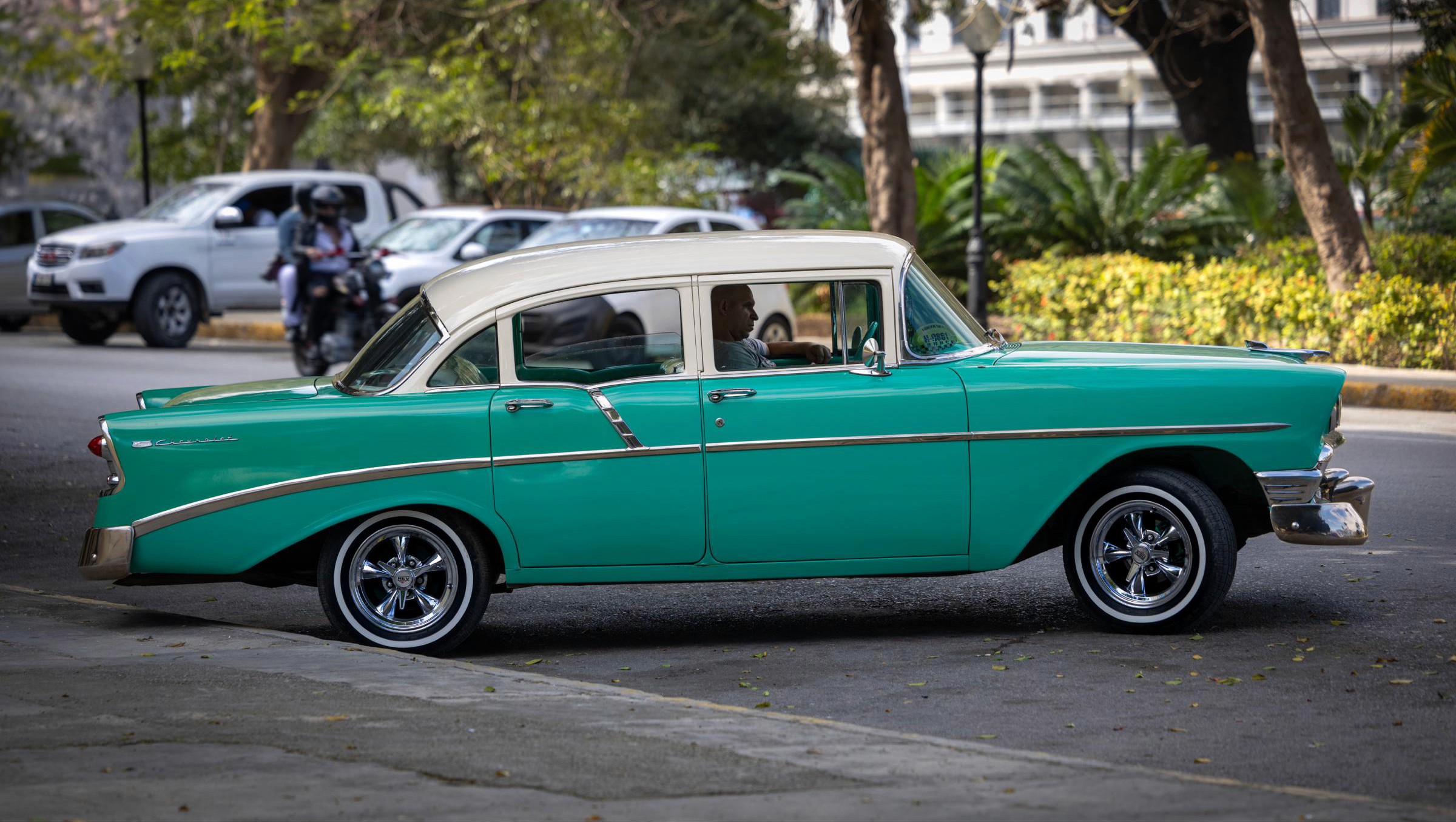 A 1956 Chevrolet 210 Sedan parked in the shade awaits a customer.