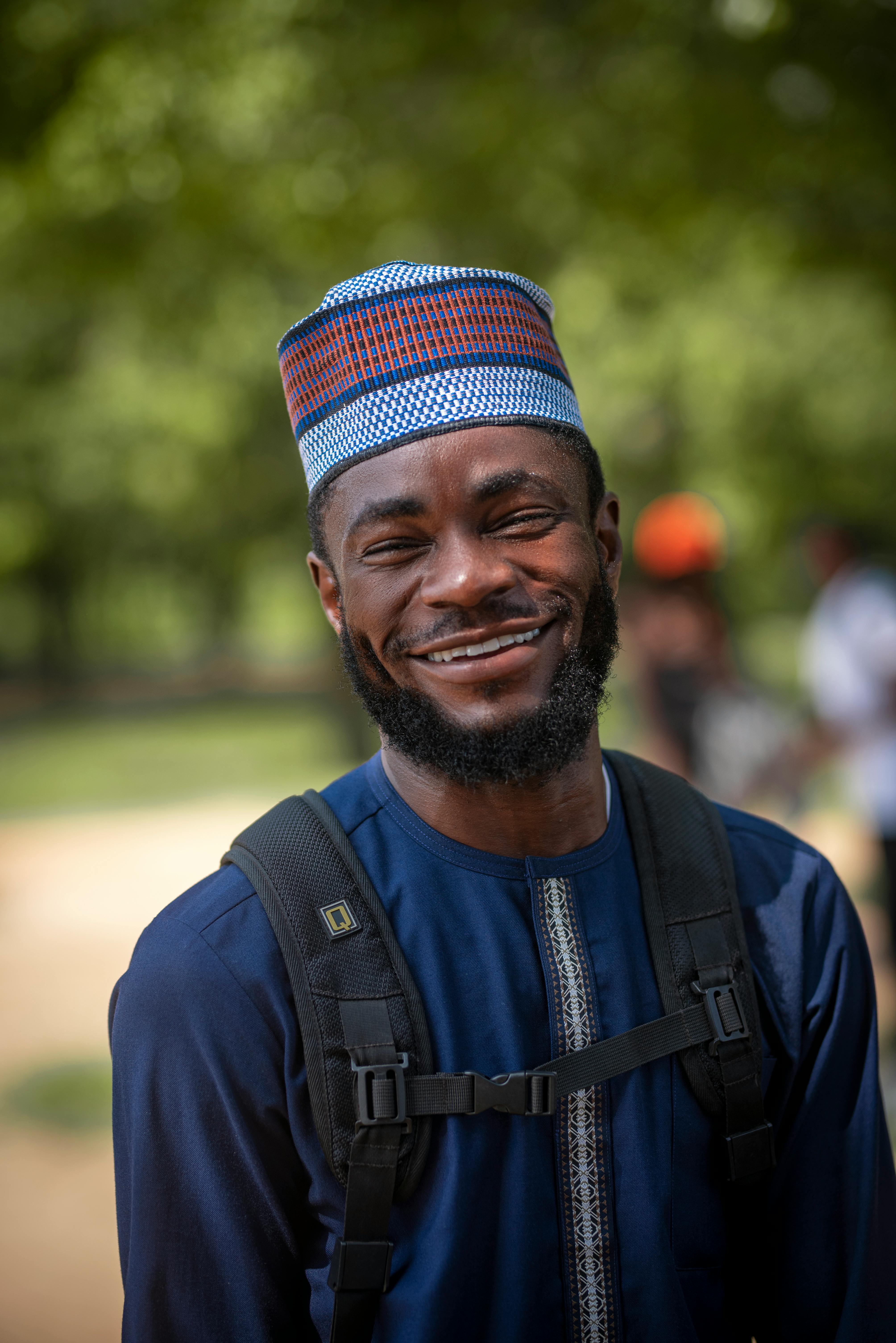 A black man wearing a cap shirt smiling