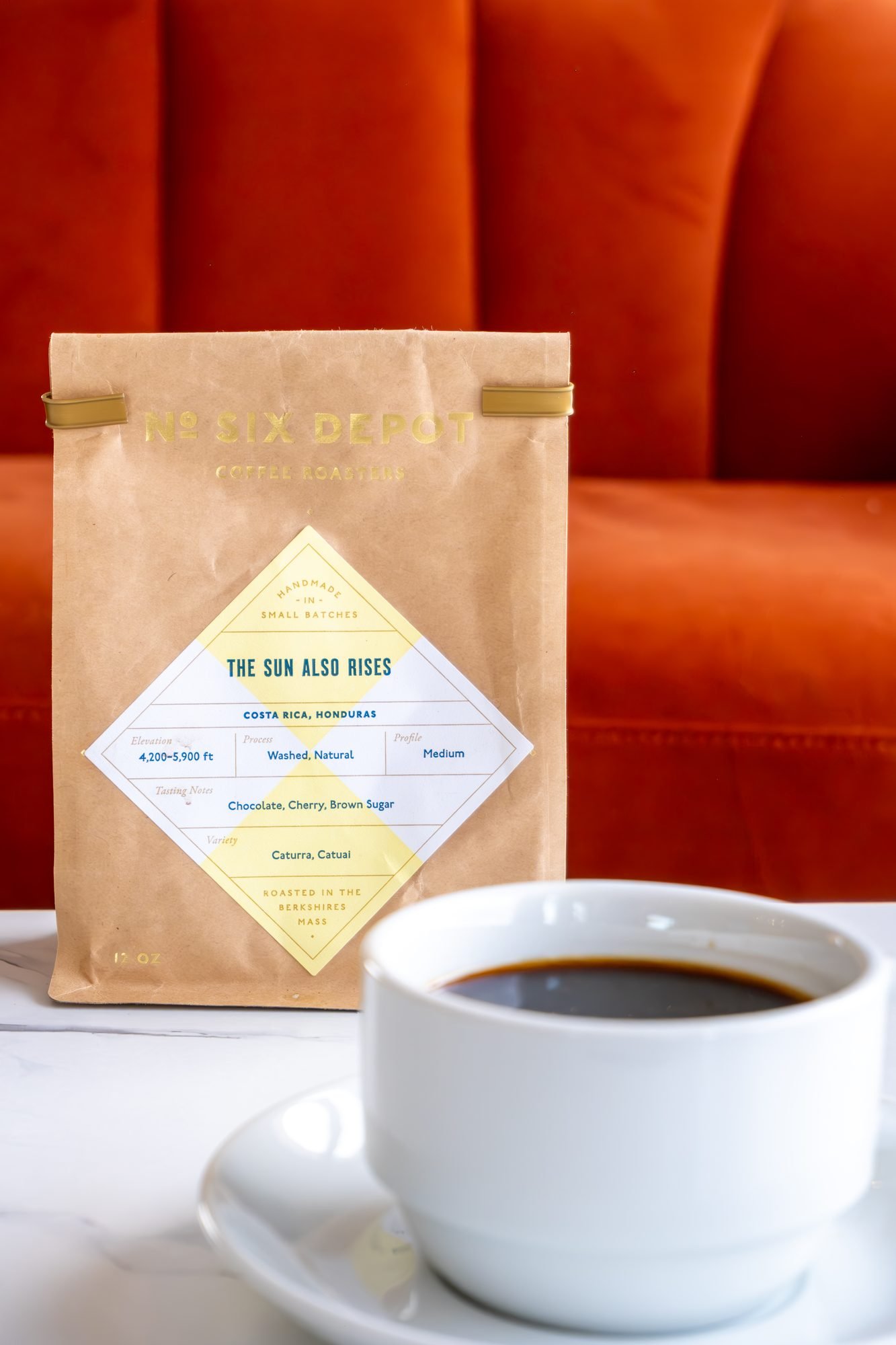 A bag of Six Depot beans beside a cup of coffee