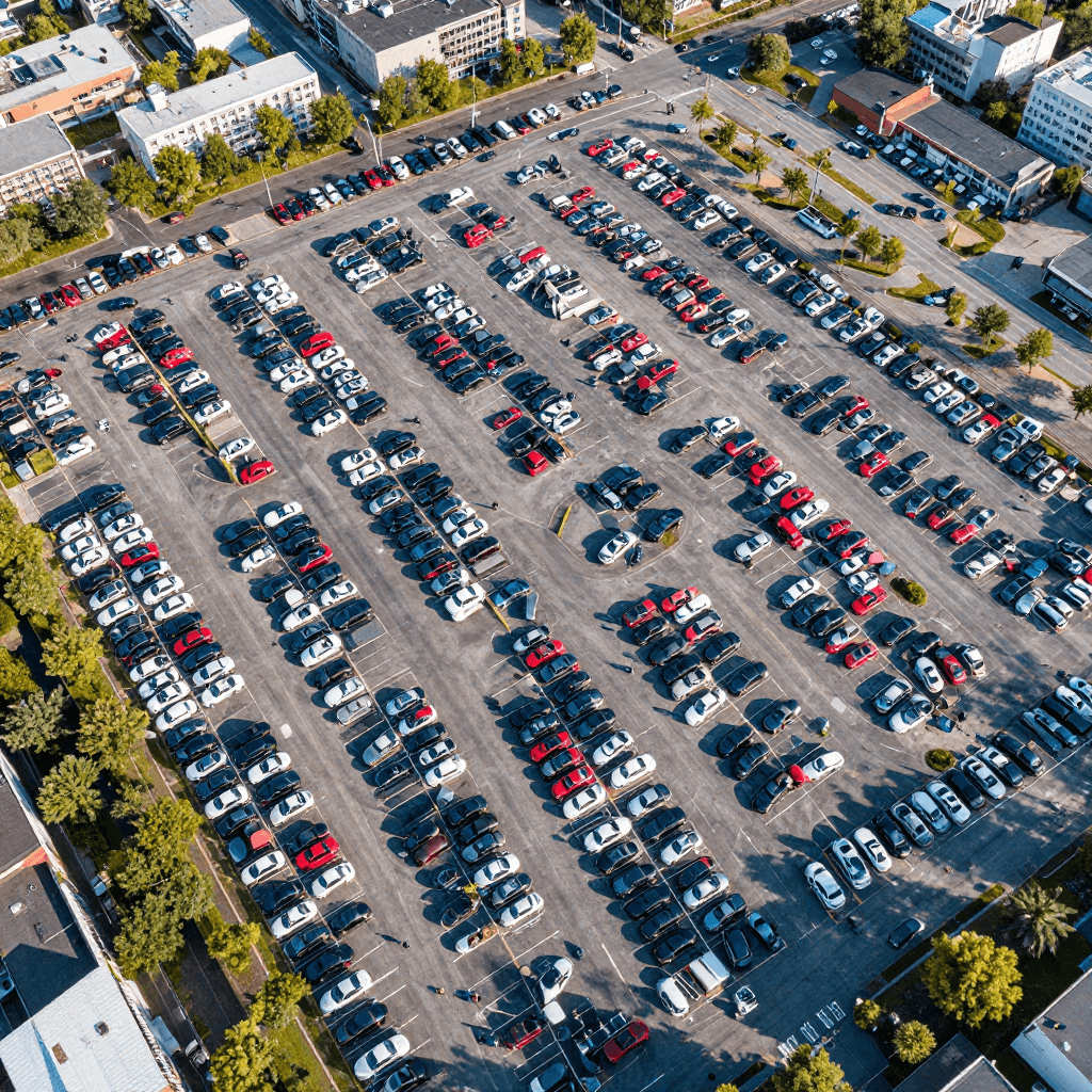 Modern glass and wood cabin with a cozy outdoor deck featuring wicker furniture, surrounded by lush green trees and a serene forest setting.