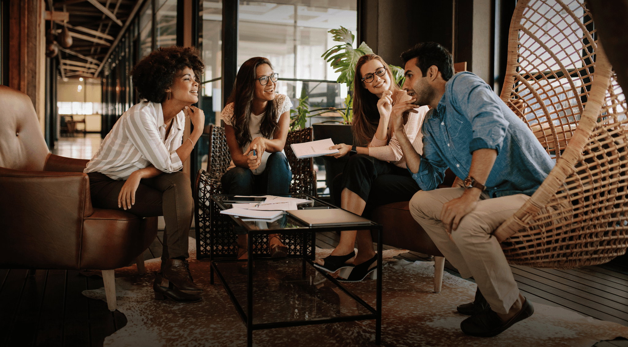 Four young professionals having a disucssion at a coffee table