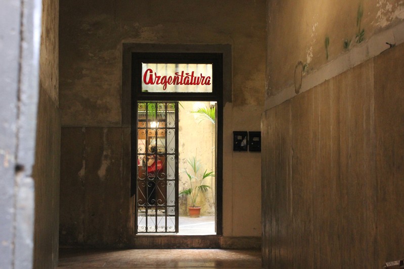 argentatura shop name written with red letters on a window above the entrance door