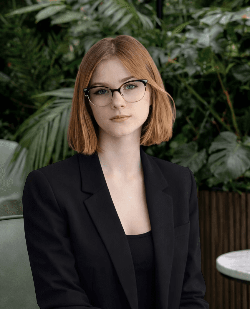 Casual studio portrait of a bearded man with curly hair in a white shirt, arms crossed, on a light gray background.