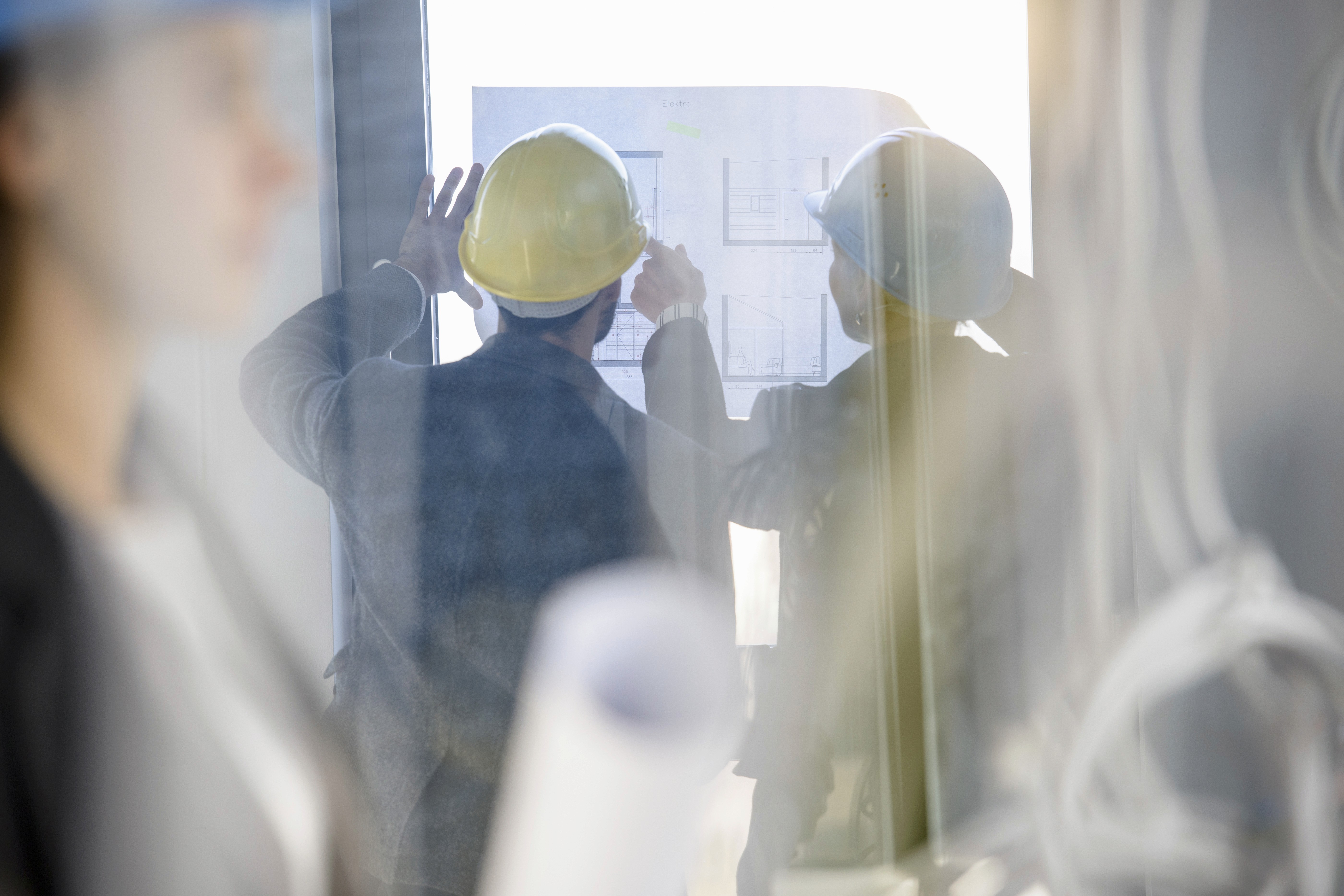 General contractor and architect reviewing plans on a jobsite