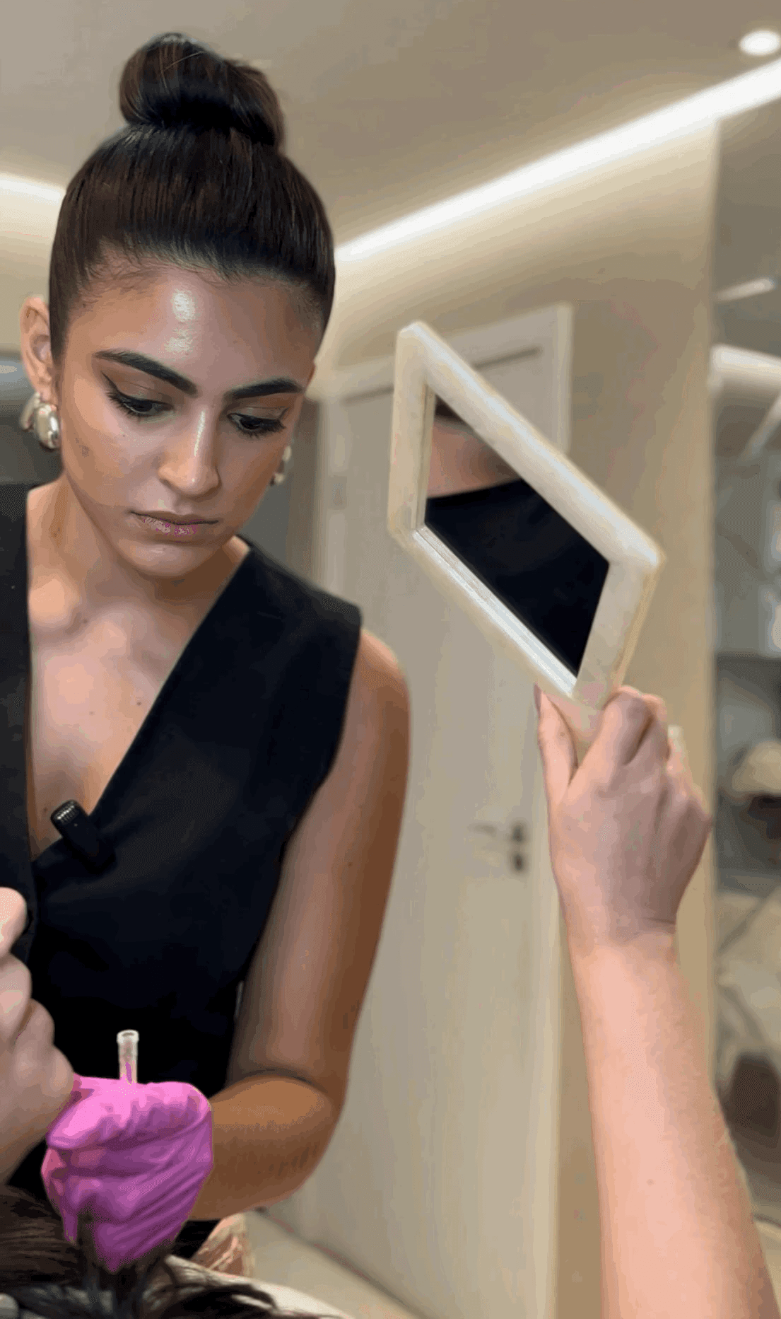 A person with curly hair sits at a desk, working on a laptop in a cozy, well-lit environment.