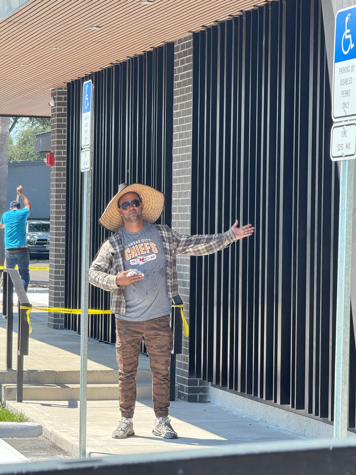 Construction workers in hard hats and vests huddle together.