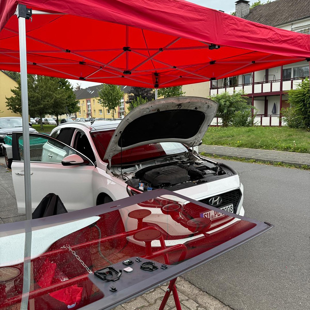 Mobiler Vor-Ort-Service – KulXpert Team repariert Fahrzeug unter rotem Service-Zelt in Bonn Rhein-Sieg
