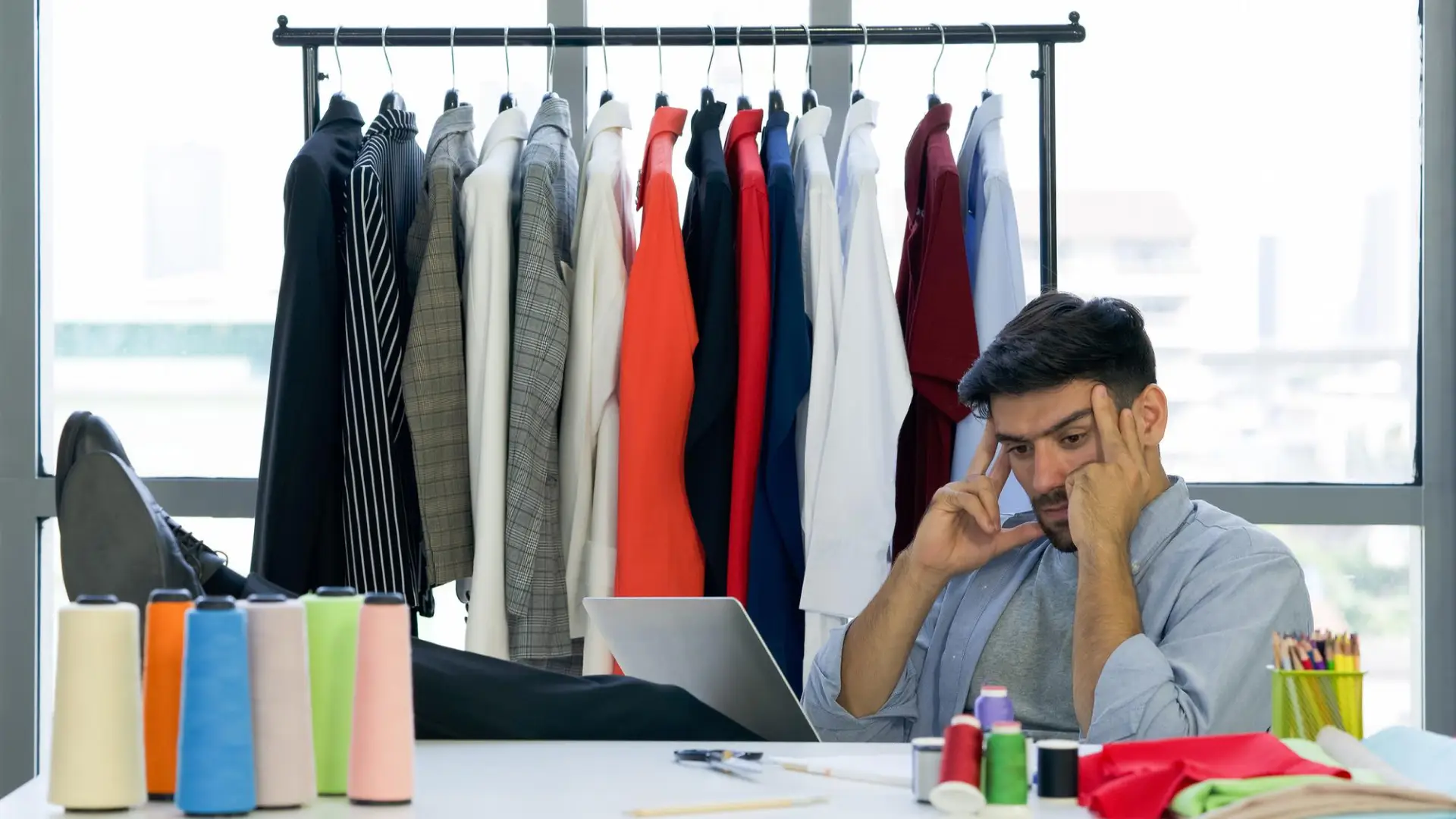 Frustrated designer stressed by TikTok Shop logistics, overwhelmed with fulfillment and shipping, facing potential penalties.