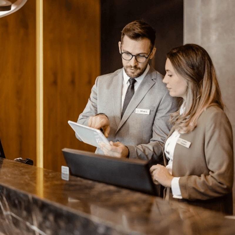 man and women behind reception desk
