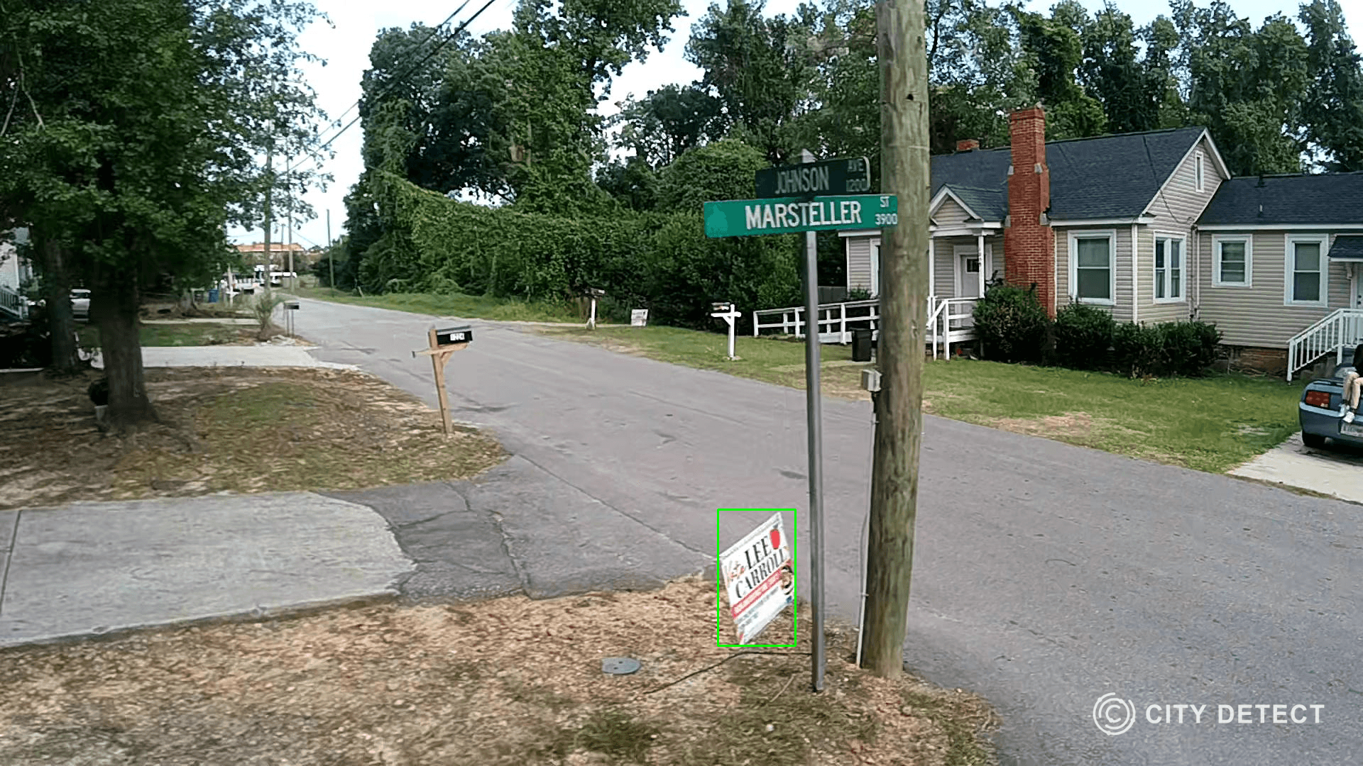 Street view with a "For Sale" sign on the corner of Crimson and Marsheller street next to a wooden pole.
