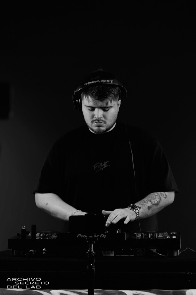 Felipe Ferreyra DJ tocando musica con una remera negra y gradiente de fondo