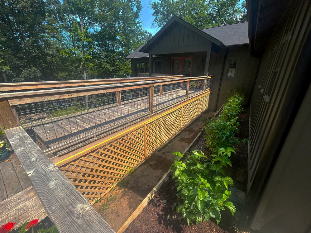 A walkway to the front door of a house, parallel to the retaining wall.
