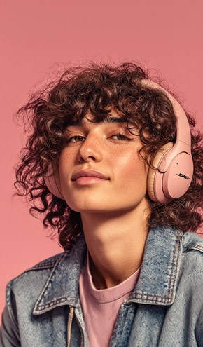 A young person listening to music with headphones on, looking at the camera