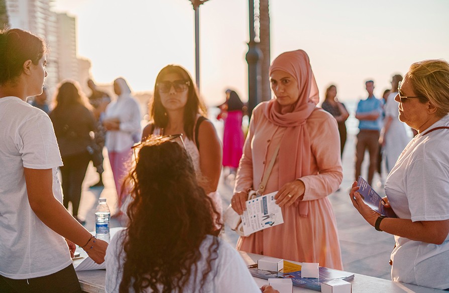 Women talking to Becky's Button volunteers at a kiosk on Beirut's Corniche