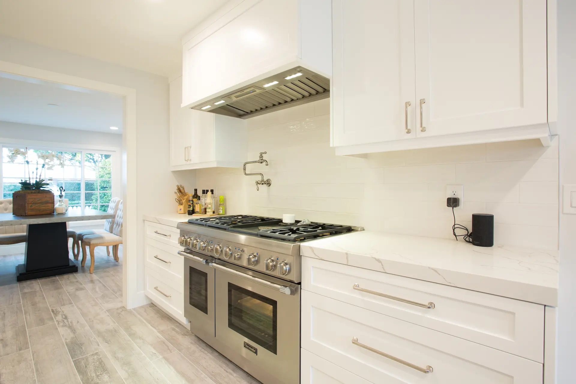 Modern white kitchen, stainless steel appliances, open to living area, Dana Point Cape Cod remodel, photo by Chris Darnall.