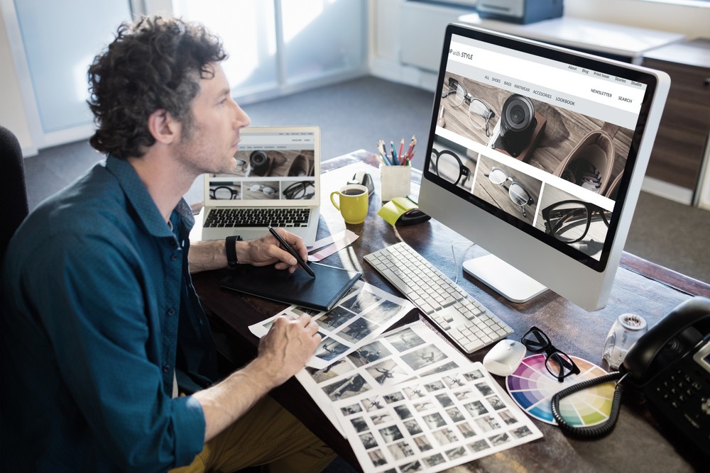 website homepage against photographer working on his computer
