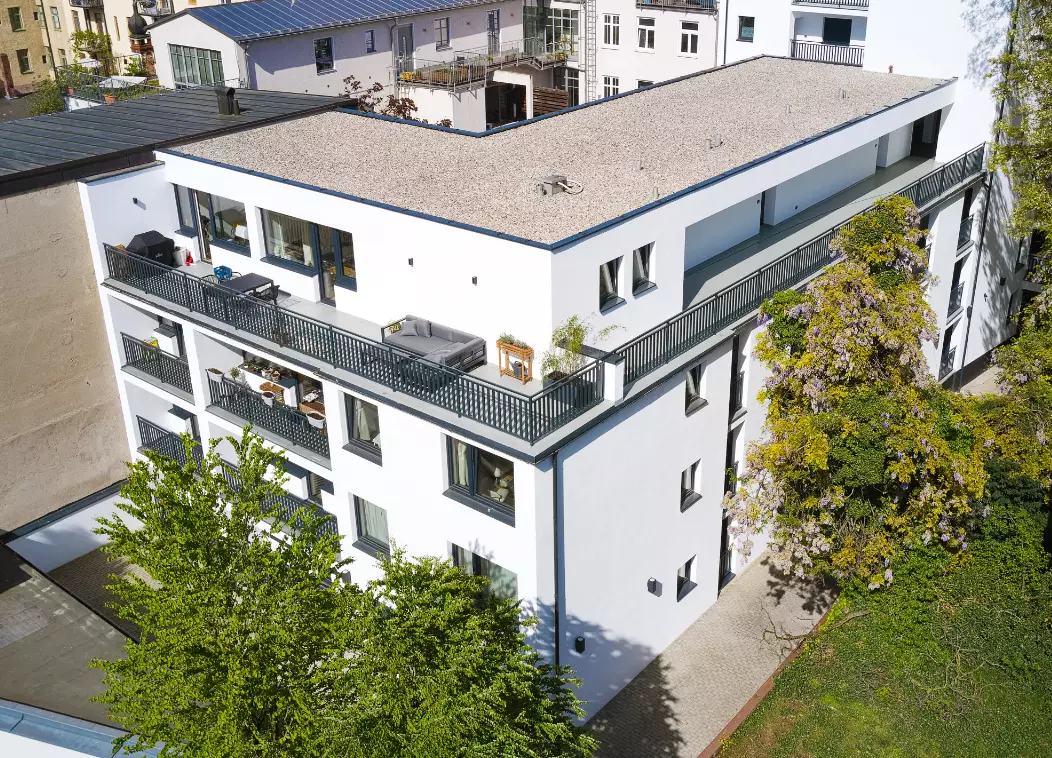Modernes Wohngebäude der Derag Immobilienverwaltung mit Balkonen und grüner Umgebung.