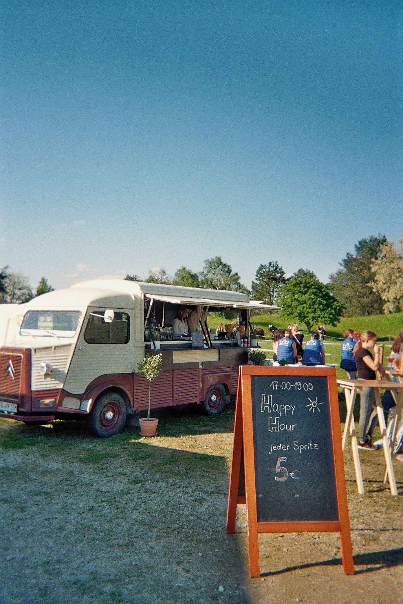 Woman in red outfit poses by a red telephone booth.