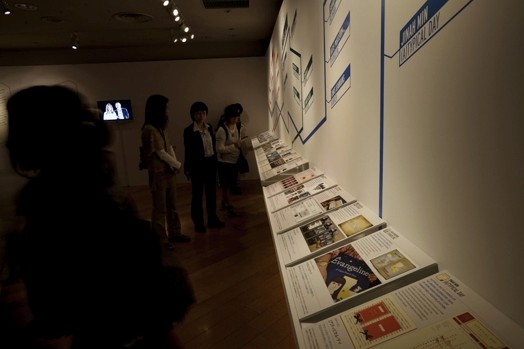 people looking at posters and flyers near a wall