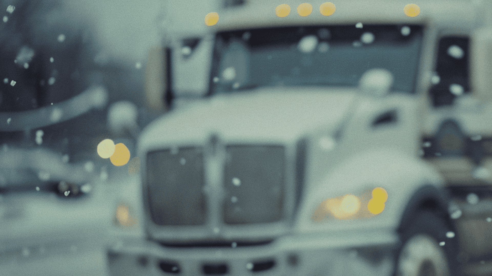 Blurred imaged of a big rig truck in the background in a snowy environment