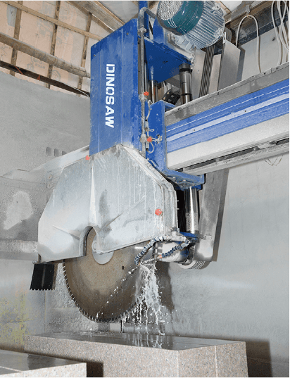 Dinosaw Bridge Cutting Machine in a workshop, illustrating its operational setting and water cooling feature for smooth cutting.