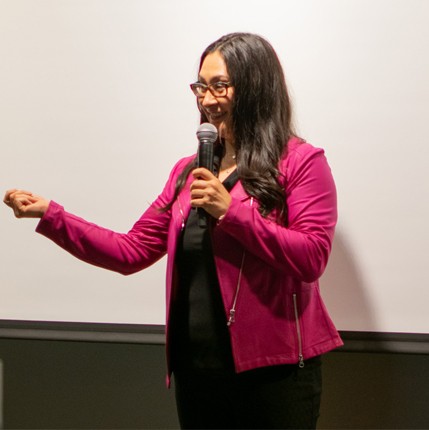 A photo of Dayna presenting and gesturing