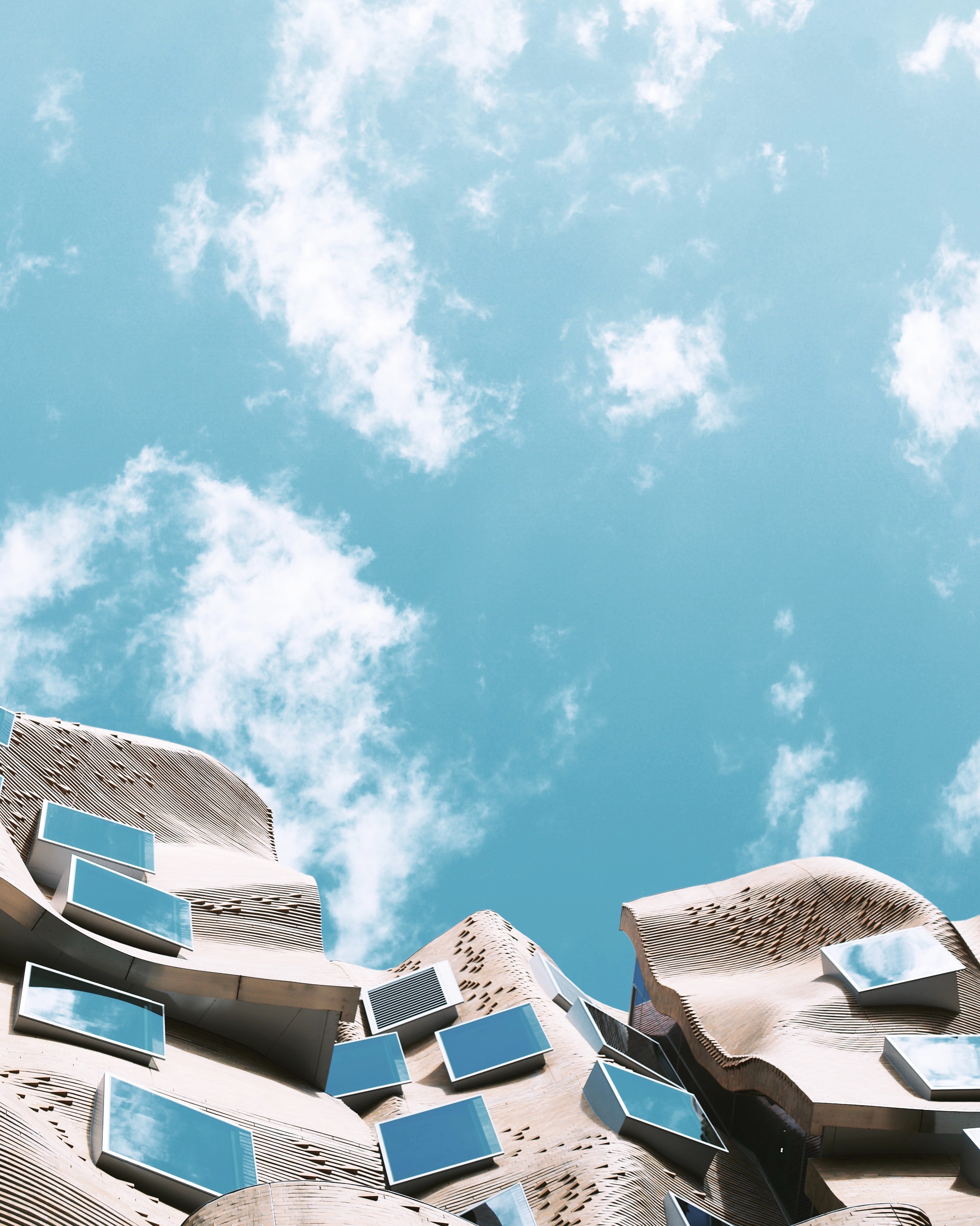 Focused woman working on a laptop in a cozy, dimly lit café with a tea glass on the table.