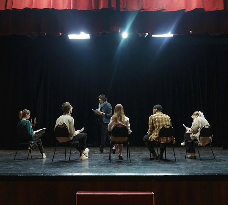 A stylish woman wearing a white hoodie and black glasses