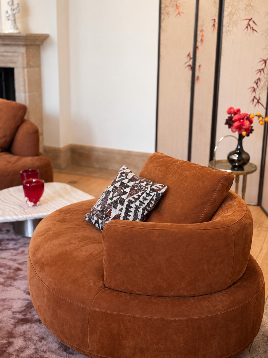 Rust velvet lounge chair with a graphic cushion