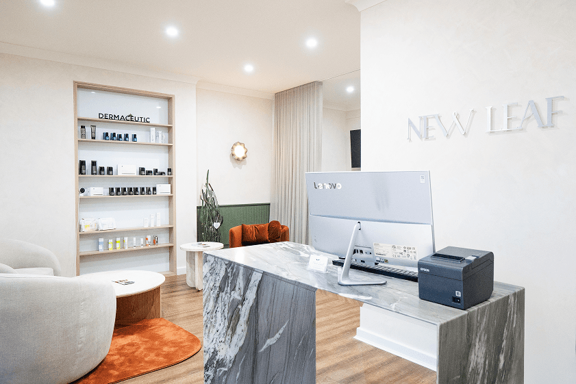 New Leaf Cosmetics space with a desk, chair, shelves, and comfortable seating area in neutral tones.