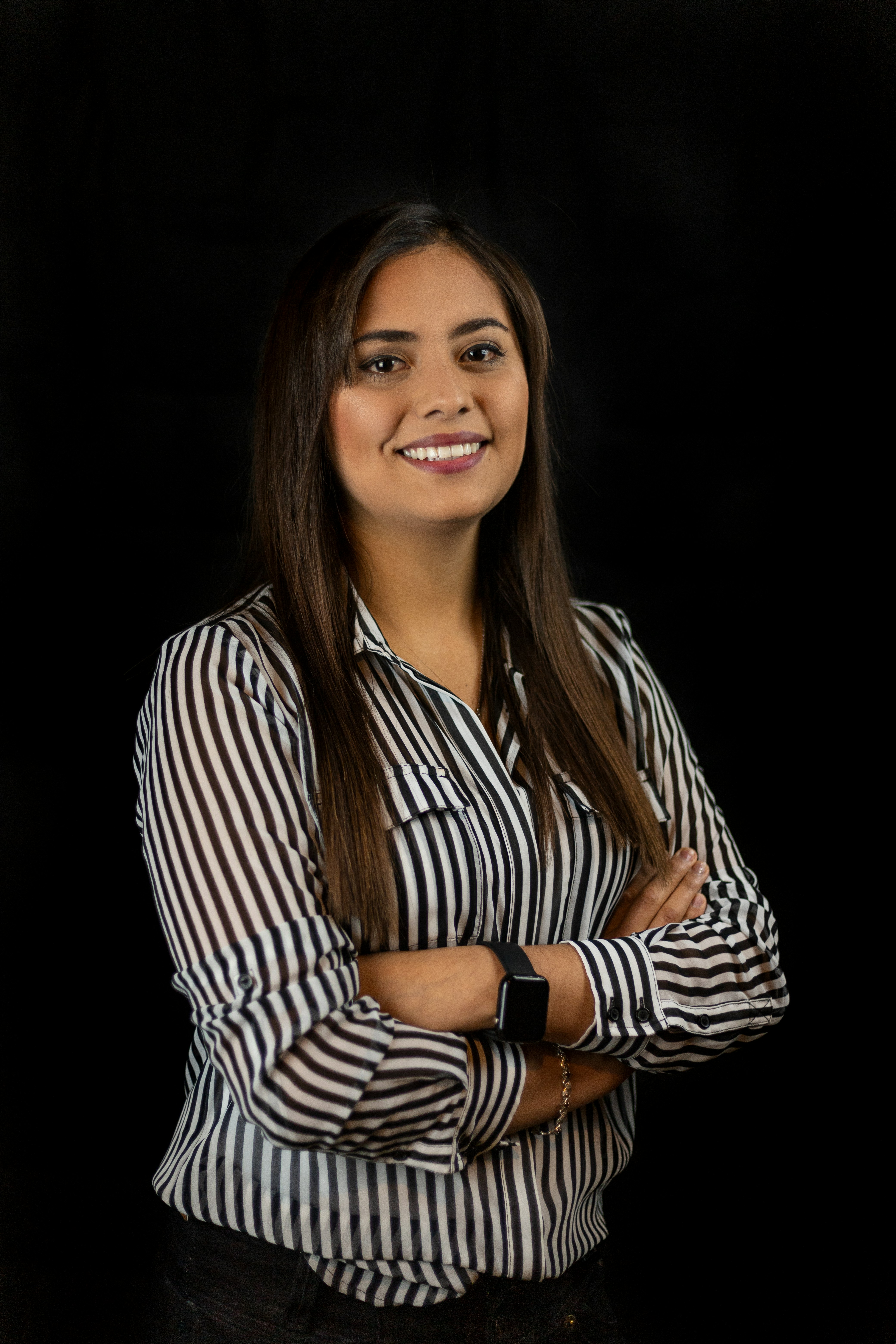 A businesswoman sitting at her desk, smiling and looking at the camera.