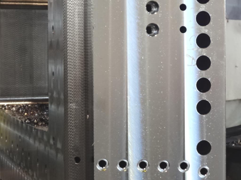 Dettaglio tecnico di una componente industriale in metallo con fori circolari di precisione, che illustra un particolare di uno stampo per la produzione meccanica.