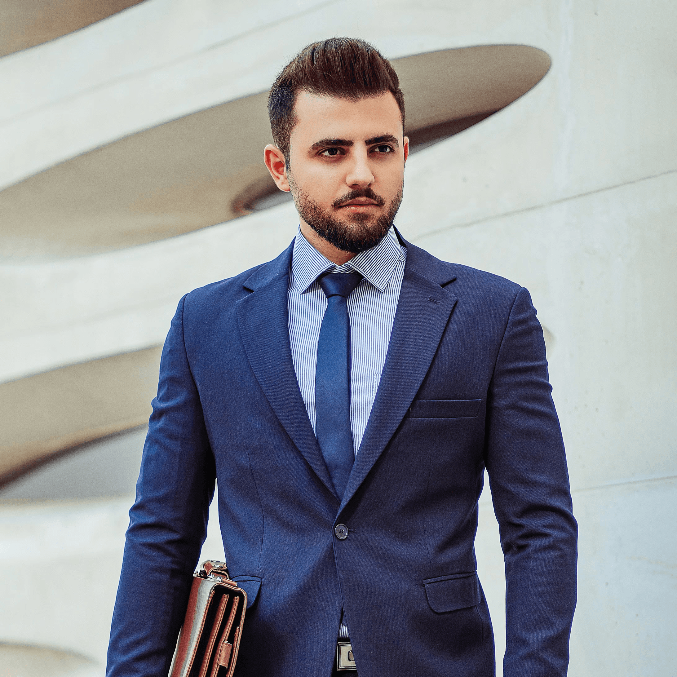 man in black suit jacket holding brown leather bag